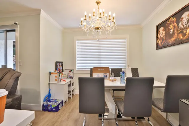 a view of a dining room with furniture wooden floor and a chandelier