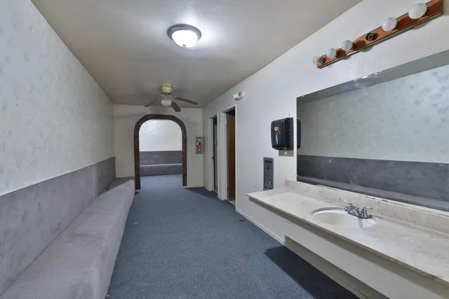 a en suite bathroom with a granite countertop sink and a mirror