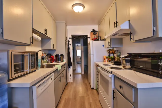 a kitchen with stainless steel appliances granite countertop a stove a sink and a refrigerator
