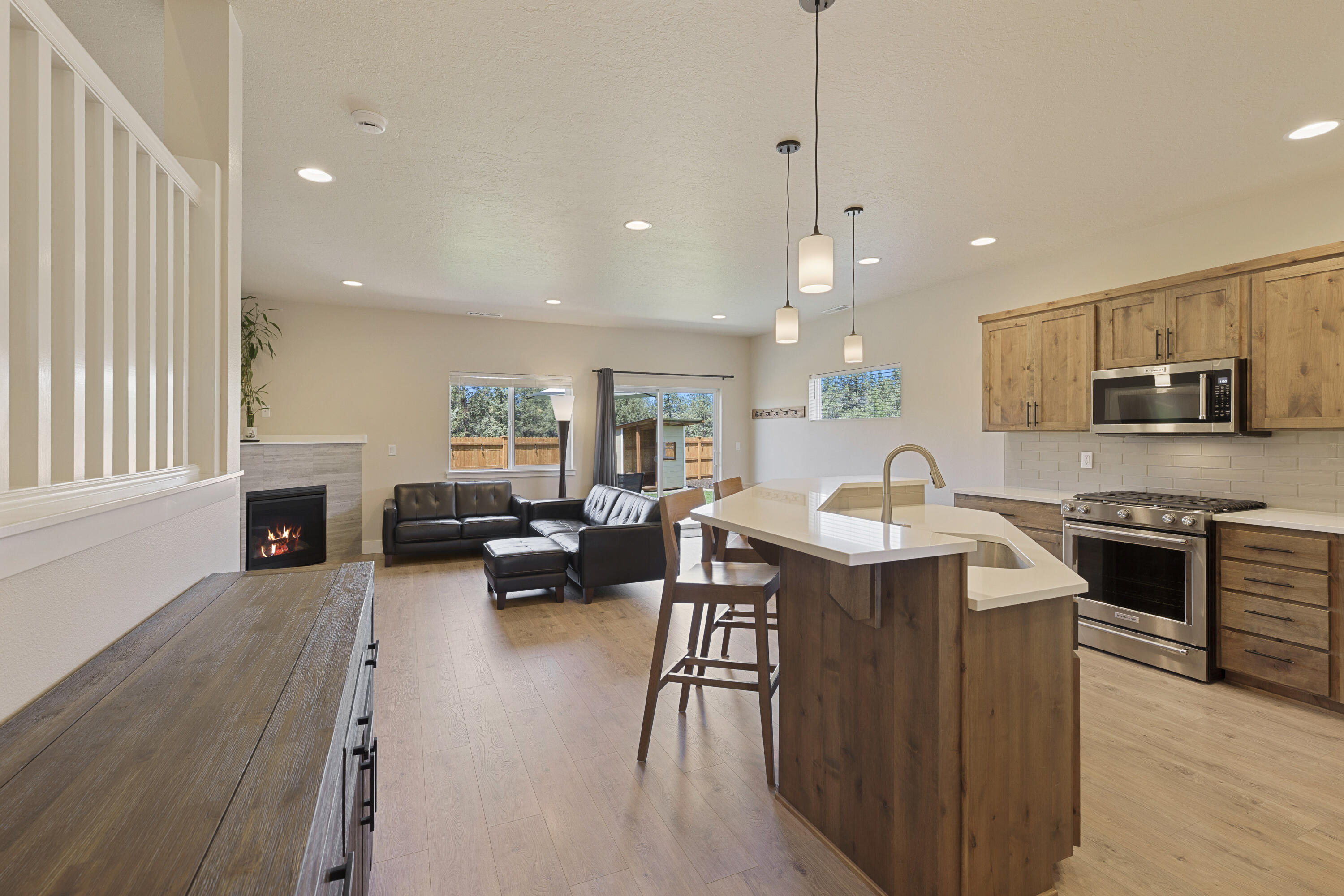 4999 Southwest Yew Place Redmond, OR 97756 - Photo 9 of 50 a kitchen with stainless steel appliances granite countertop a sink stove and wooden floor