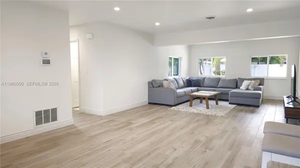 a living room with furniture and a wooden floor