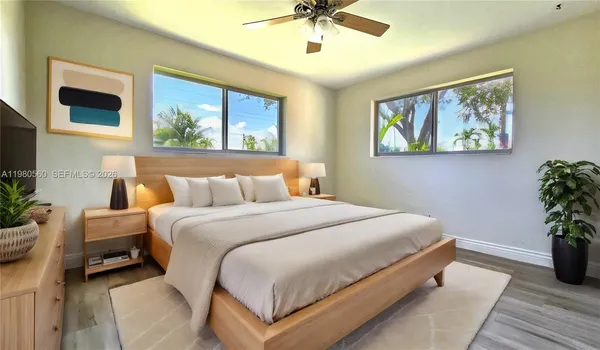 a bedroom with bed and a painting on the wall