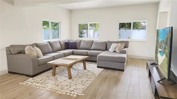 a living room with furniture flat screen tv and a window