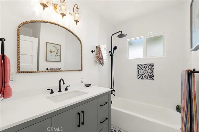 a bathroom with a tub sink and mirror