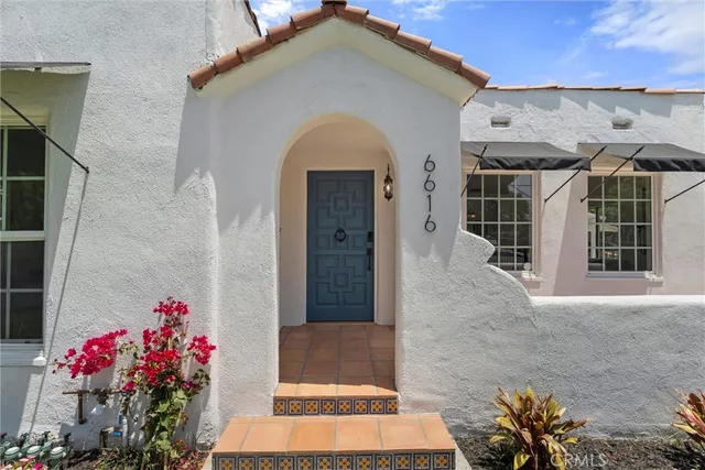 a front view of a house with a flower garden