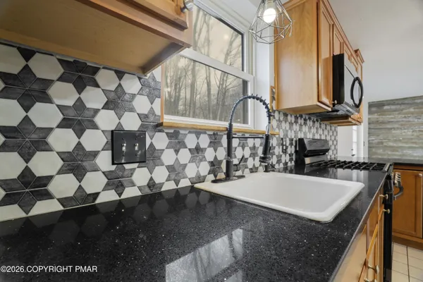 a kitchen with stainless steel appliances granite countertop a sink a stove and a refrigerator