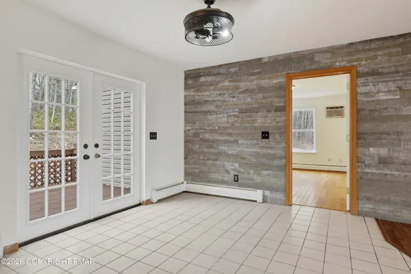 a view of an empty room with wooden floor fireplace and a window