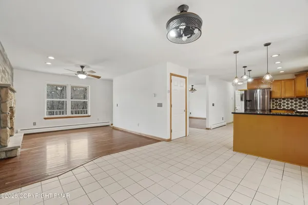 an empty room with windows and fireplace