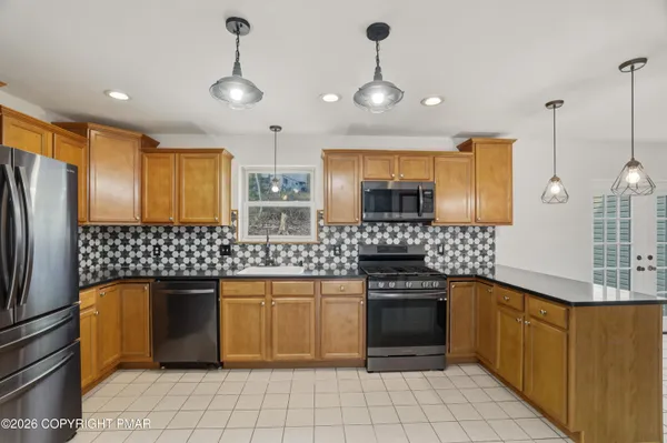a kitchen with stainless steel appliances granite countertop a stove a sink and a refrigerator