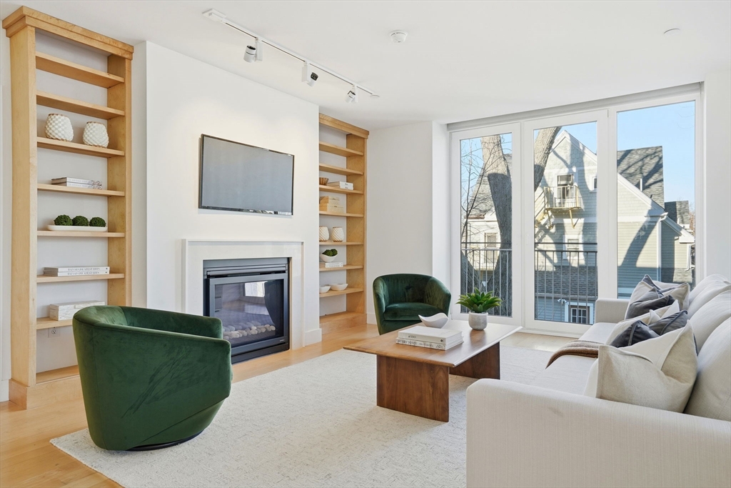 a living room with furniture large window and fireplace