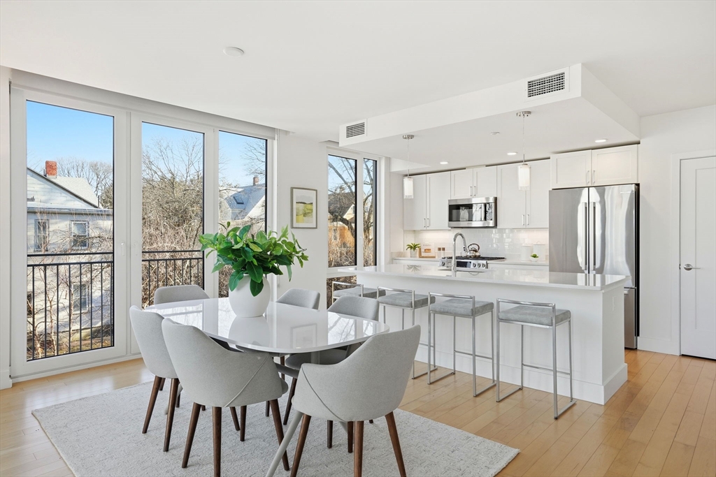 7 Beech Street, Unit 211 Cambridge, MA 02140 - Photo 4 of 17 a kitchen with stainless steel appliances granite countertop a dining table chairs and granite counter tops
