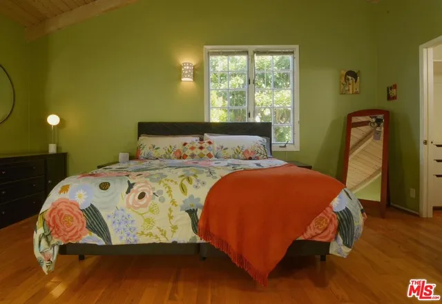 a bed sitting in a bedroom next to a window