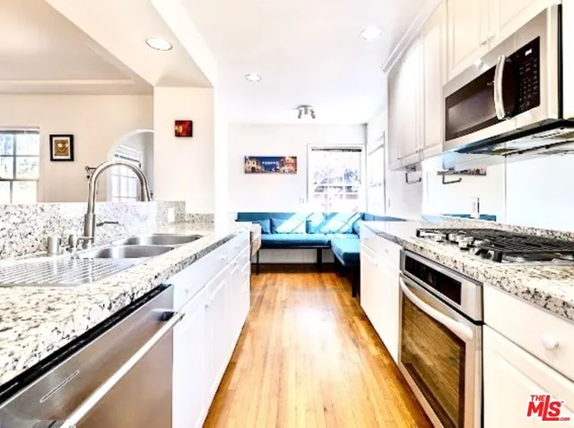 a kitchen with stainless steel appliances granite countertop a stove and a sink