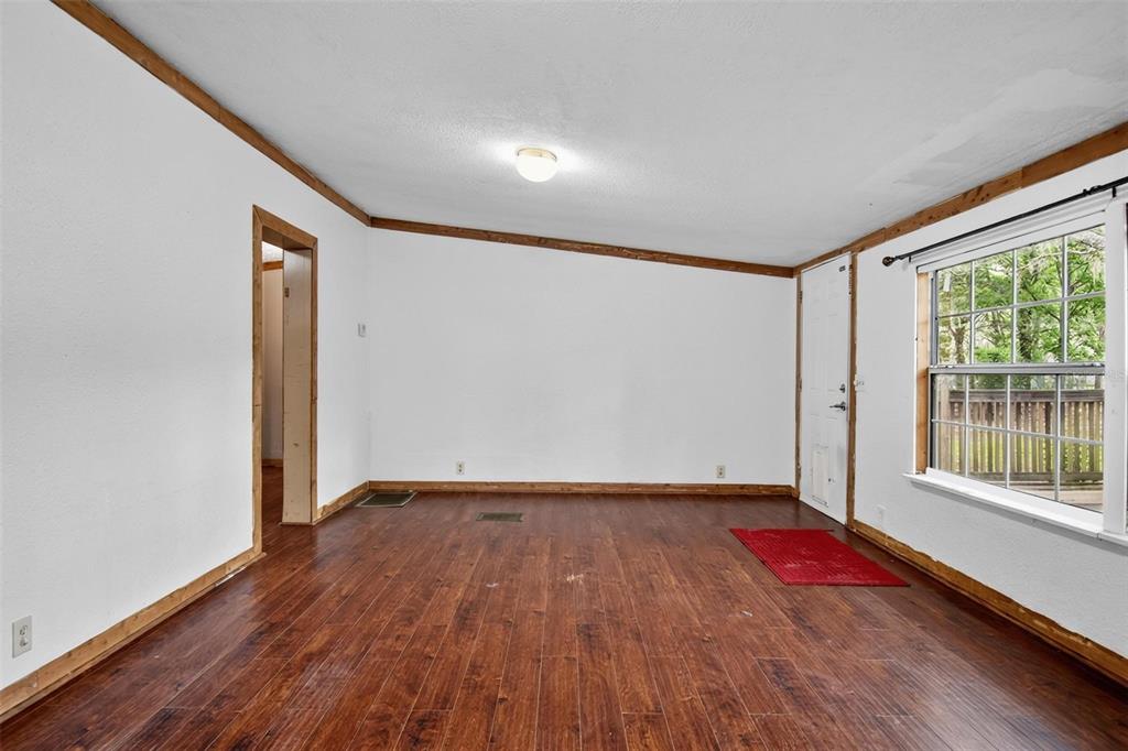 156 Kingfish Road Pomona Park, FL 32181 - Photo 16 of 55 a view of an empty room with wooden floor and a window