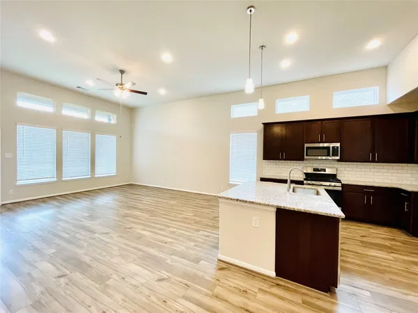 a kitchen with a stove and a wooden floor