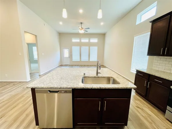 a kitchen with a sink dishwasher a refrigerator and a flat screen tv