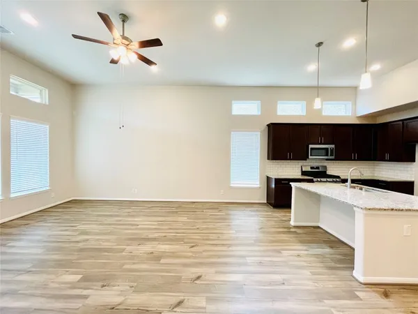 a view of kitchen with microwave stove top oven and cabinets