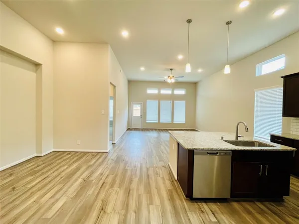 a view of a kitchen with kitchen island a sink dishwasher with wooden floor