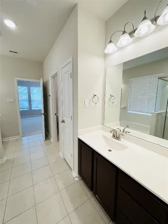 a spacious bathroom with a double vanity sink a mirror and a shower
