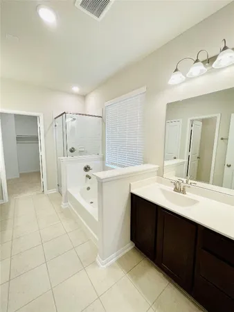 a spacious bathroom with a double vanity sink a mirror and a bathtub