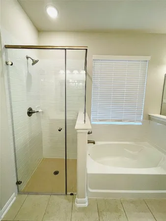 a bathroom with a shower and a bath tub