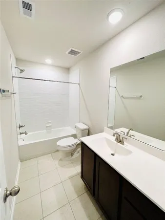 a bathroom with a bathtub shower sink mirror and toilet