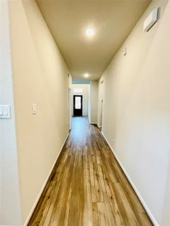 a view of a hallway with wooden floor