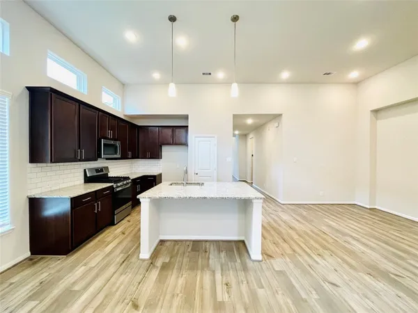 a large white kitchen with stainless steel appliances