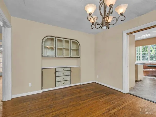 a view of a livingroom with wooden floor and a large window