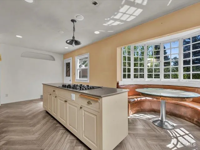 a kitchen with stainless steel appliances granite countertop a stove and a large window