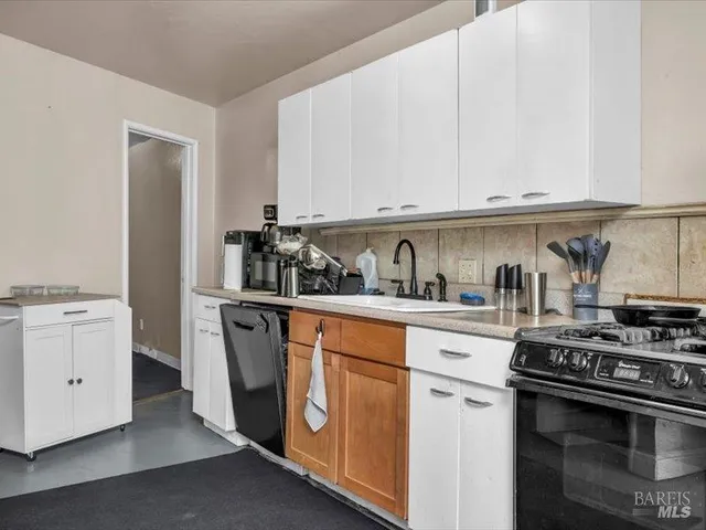 a kitchen with white cabinets and white appliances