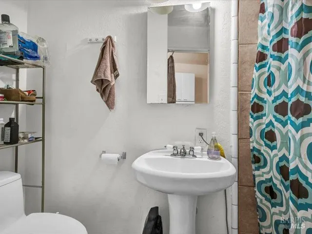 a bathroom with a sink and mirror with toilet