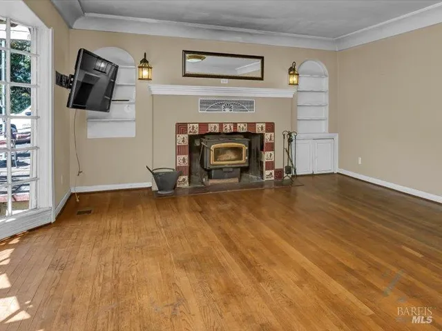 an empty room with windows and fireplace