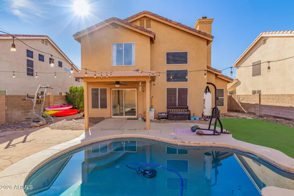 a view of a house with pool and chairs