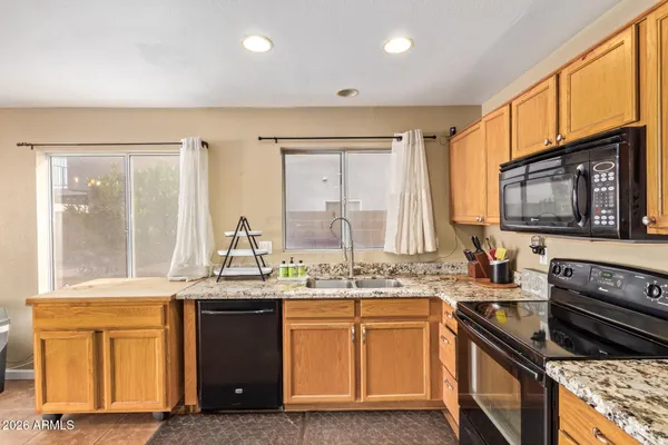 a kitchen with stainless steel appliances granite countertop a stove a sink and a microwave