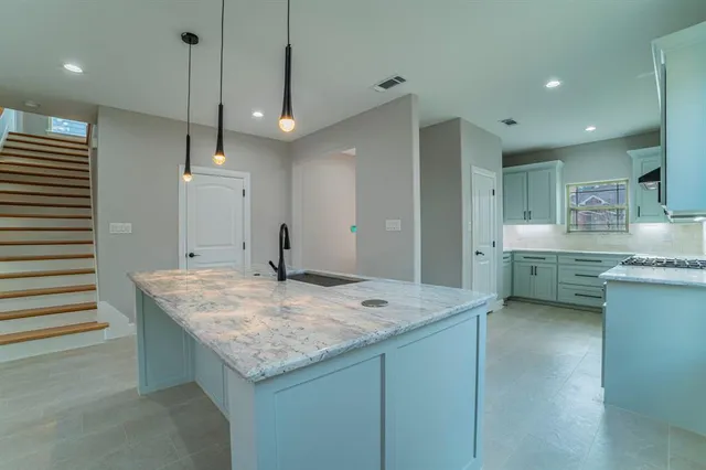 a kitchen with center island a sink stainless steel appliances and cabinets