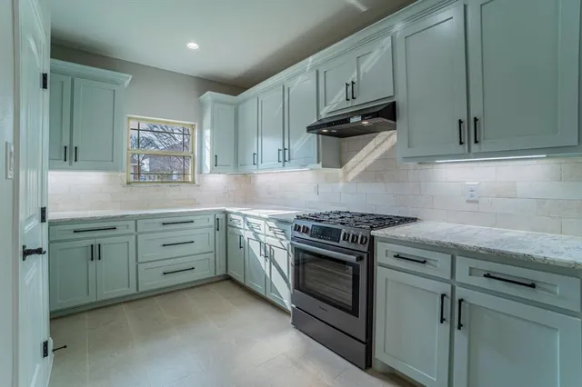 a kitchen with granite countertop cabinets stainless steel appliances and a sink