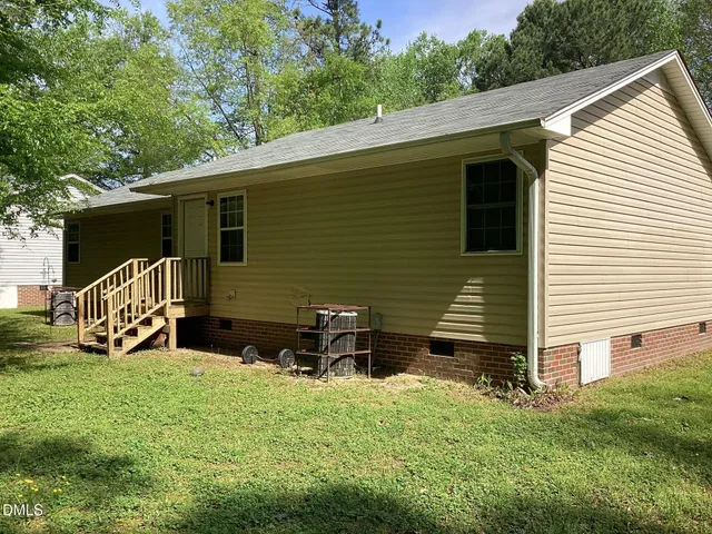 a backyard of a house with wooden fence and deck