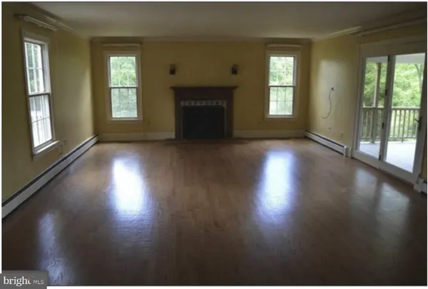 a view of a livingroom with wooden floor and a fireplace