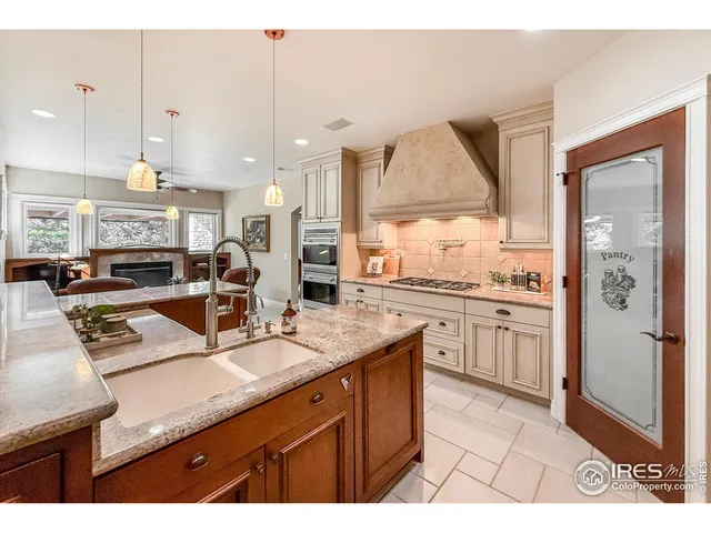 a kitchen with stainless steel appliances kitchen island granite countertop a table chairs sink and cabinets