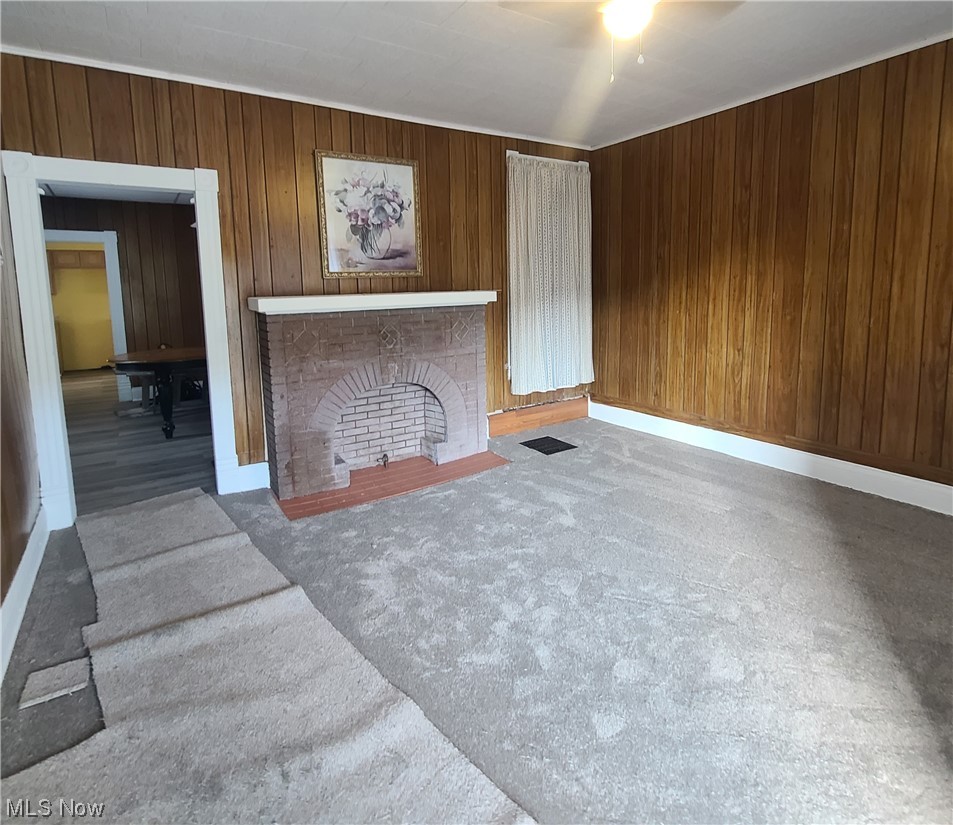 854 National Road Bridgeport, OH 43912 - Photo 5 of 27 Living room featuring wood walls and a fireplace