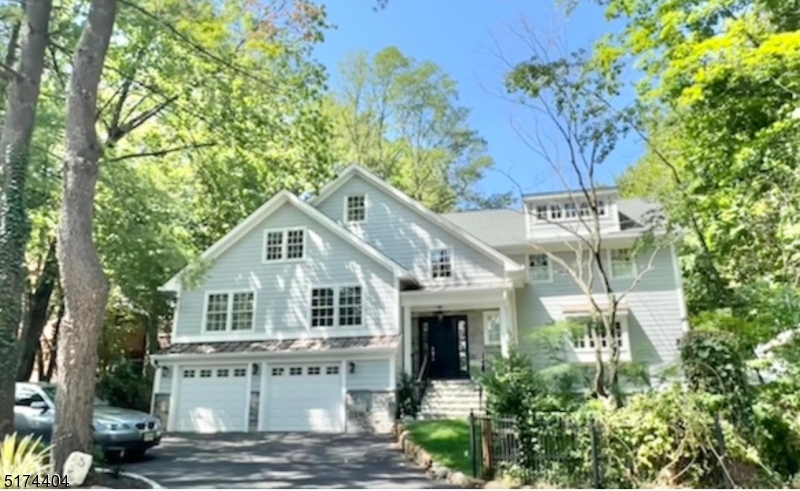 a view of house with outdoor seating and covered with trees
