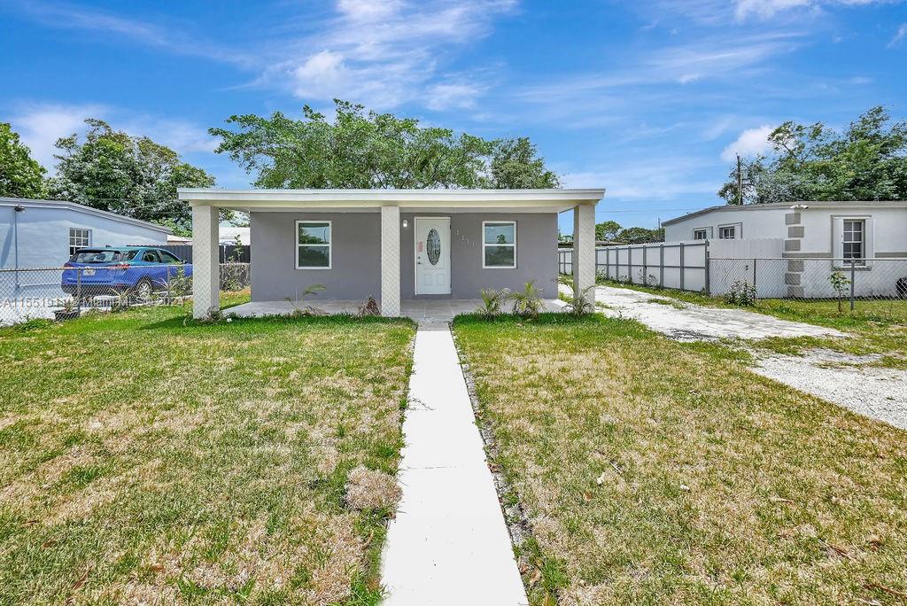 2370 Service Road Opa-Locka, FL 33054 - Photo 3 of 28 a view of a yard in front of a house with plants and large tree