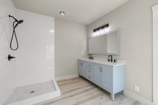 a bathroom with a double vanity sink and mirror