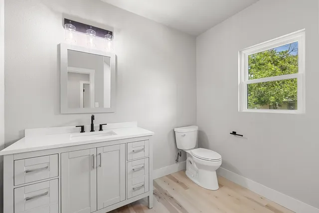 a bathroom with a toilet sink and mirror