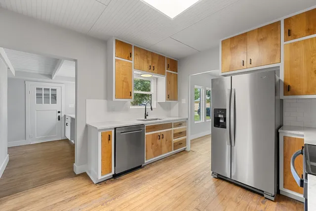 a kitchen with stainless steel appliances granite countertop a refrigerator a stove a sink and a microwave