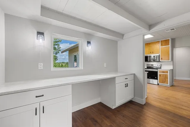 a view of kitchen with stainless steel appliances cabinets and wooden floor