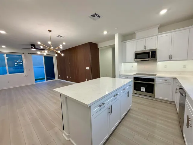 a view of a kitchen with wooden floor and staircase