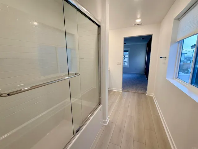 an empty room with a window and a fan