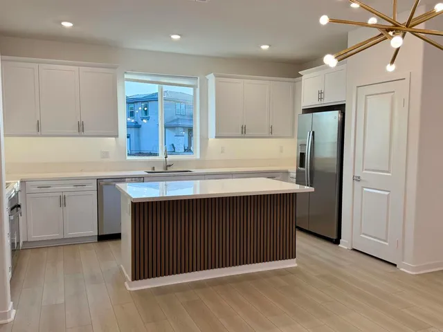 a kitchen with stainless steel appliances a sink and a refrigerator